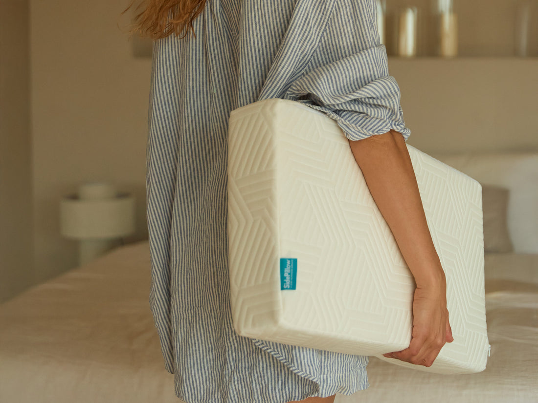 Vrouw draagt rechthoekig traagschuim hoofdkussen voor zijslapers met SidePillow-label