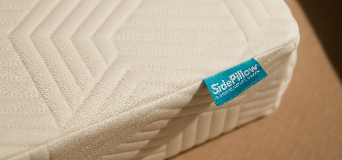 Close-up van de hoek van het SidePillow kussen met turquoise merklabel