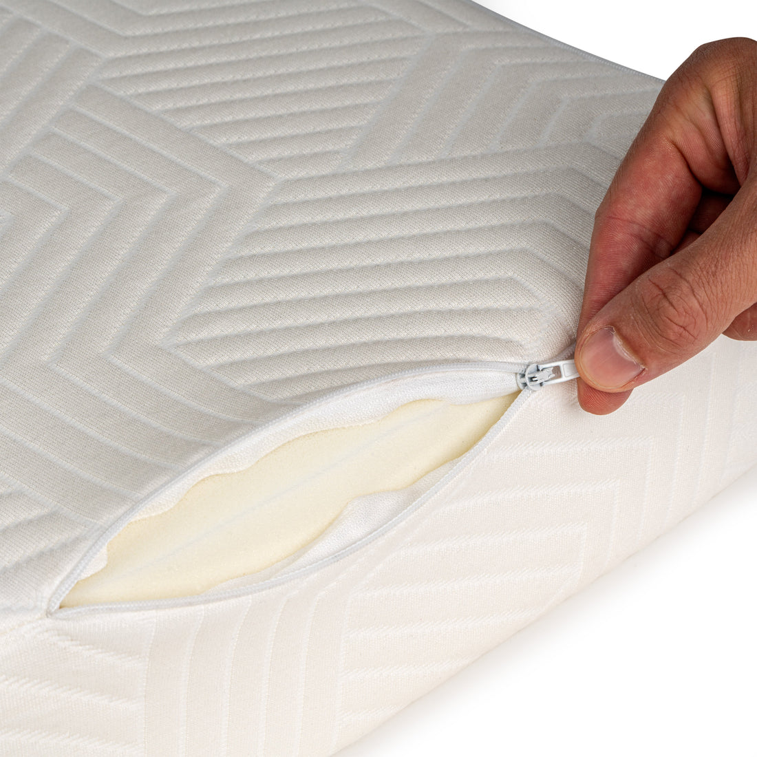 Hand opent de rits van de SidePillow tijk, de schuimkern is zichtbaar