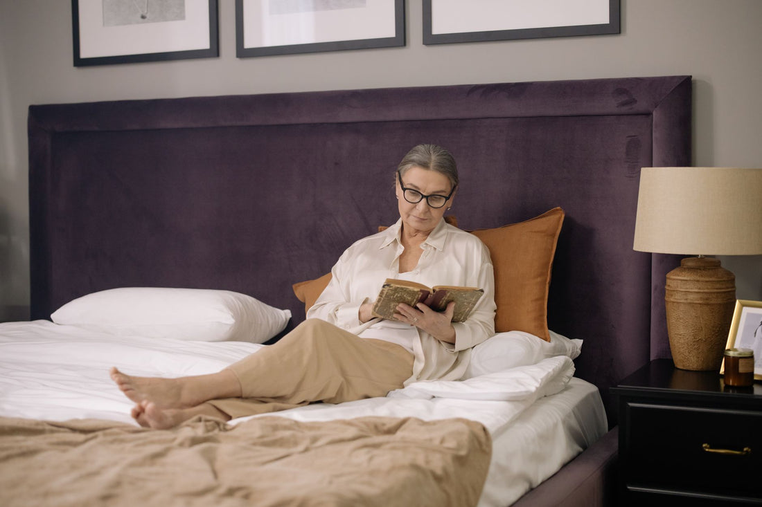 Vrouw leest een boek in bed als avondritueel