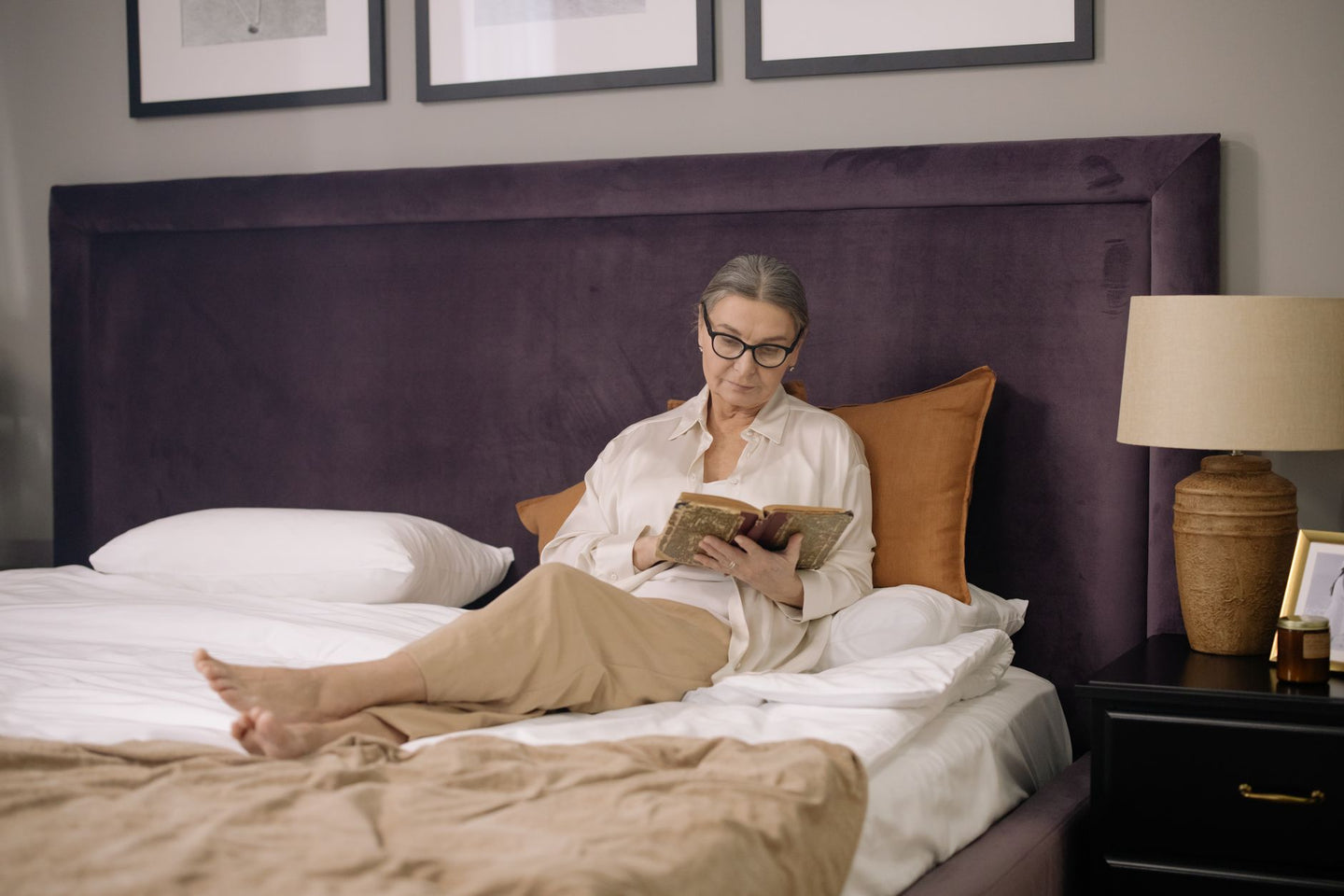 Vrouw leest een boek in bed als avondritueel