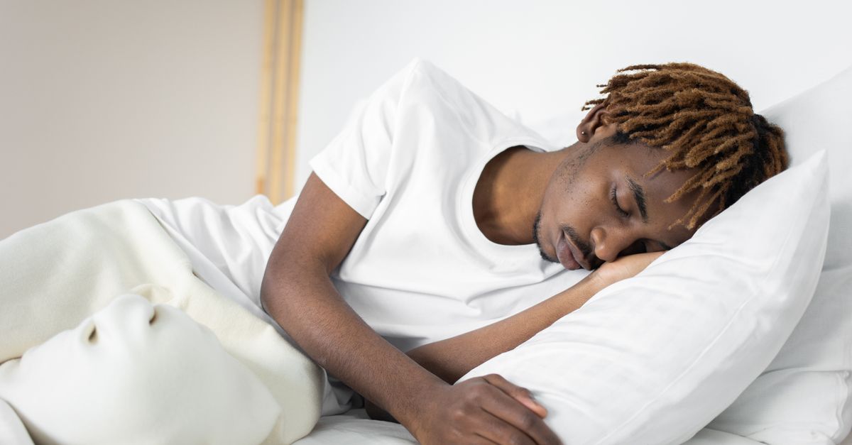 Man slaapt op zijn zij op een wit kussen