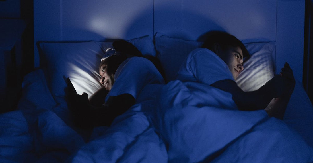 Stel ligt 's nachts wakker in bed, elk met een telefoon