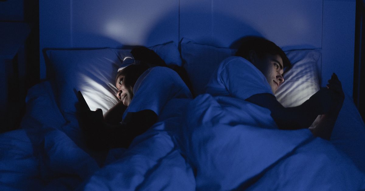 Stel ligt 's nachts wakker in bed, elk met een telefoon