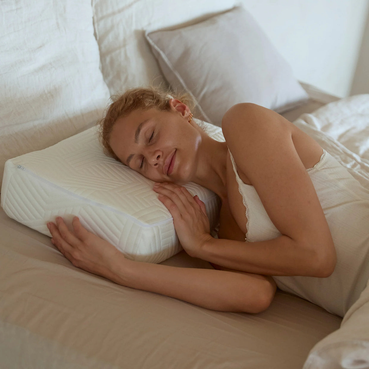Vrouw slaapt ontspannen op haar zij op een rechthoekig SidePillow hoofdkussen.