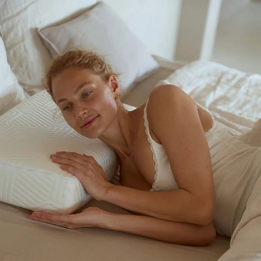 Vrouw ligt ontspannen op haar zij op een rechthoekig SidePillow hoofdkussen.
